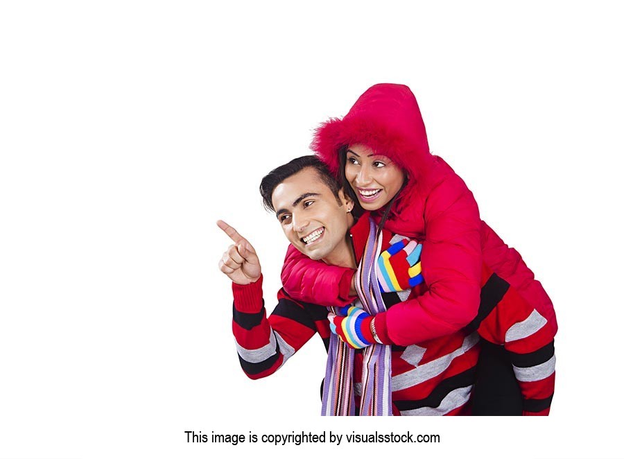 Happy couple winter clothes playing piggyback Poin