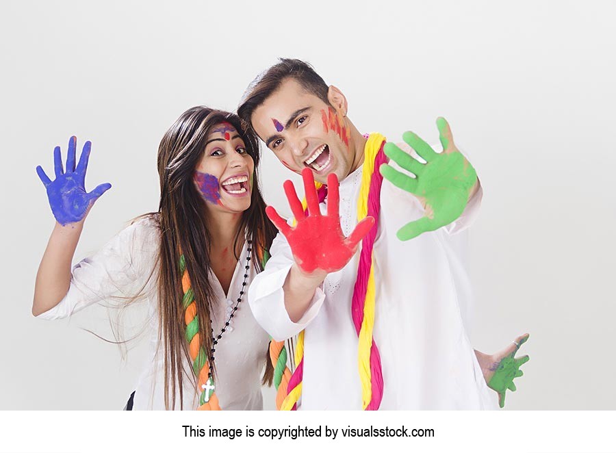 Cheerful Couple showing colored hands Holi Celebra