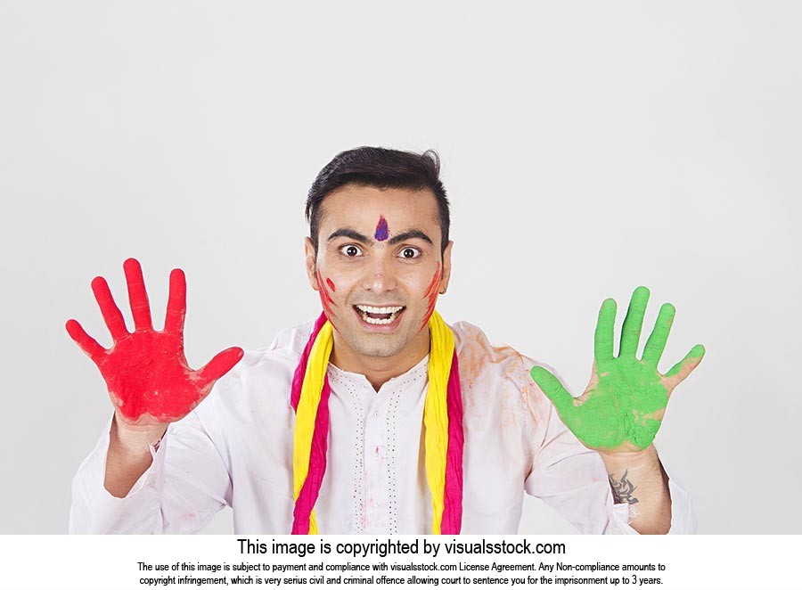 Indian Man showing colourful palm celebrating holi