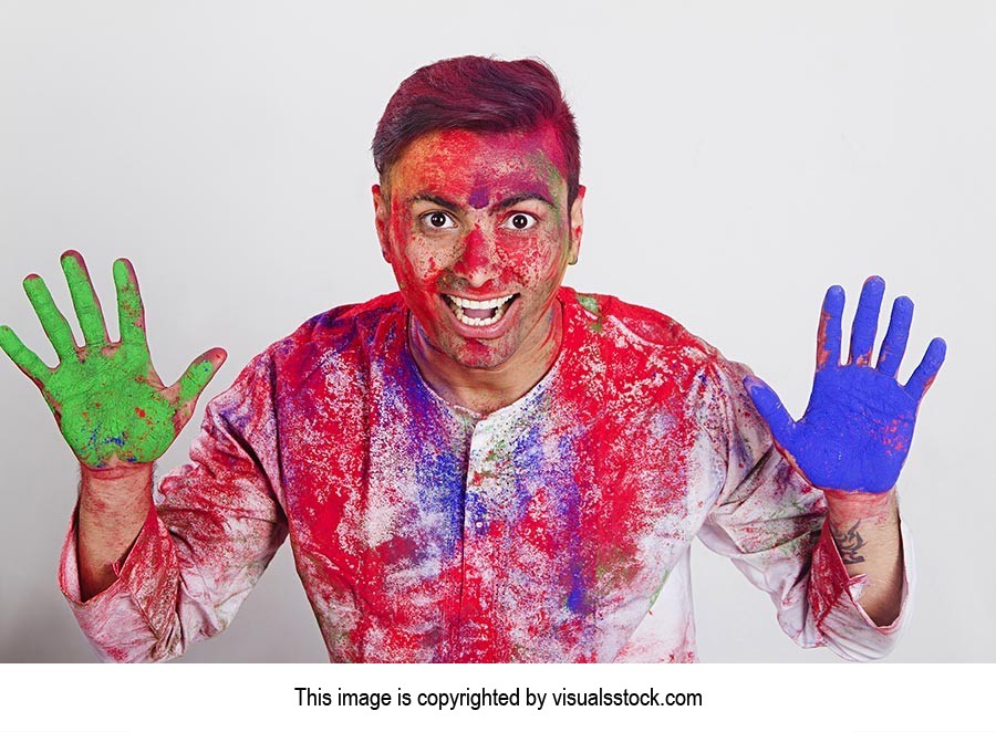 Man showing colourful palm celebrating holi Excite