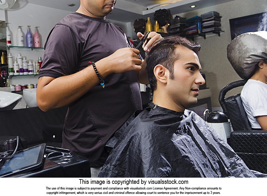 Indian customer getting hair cut by hairdresser stylist Cutting salon