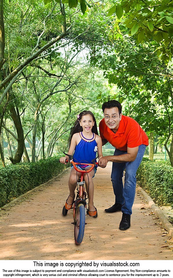 Father Teaching Daughter Ride Bicycle Sidewalk