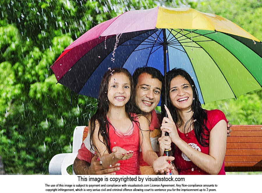 Parents Daughter Sheltering Rain Under Umbrella