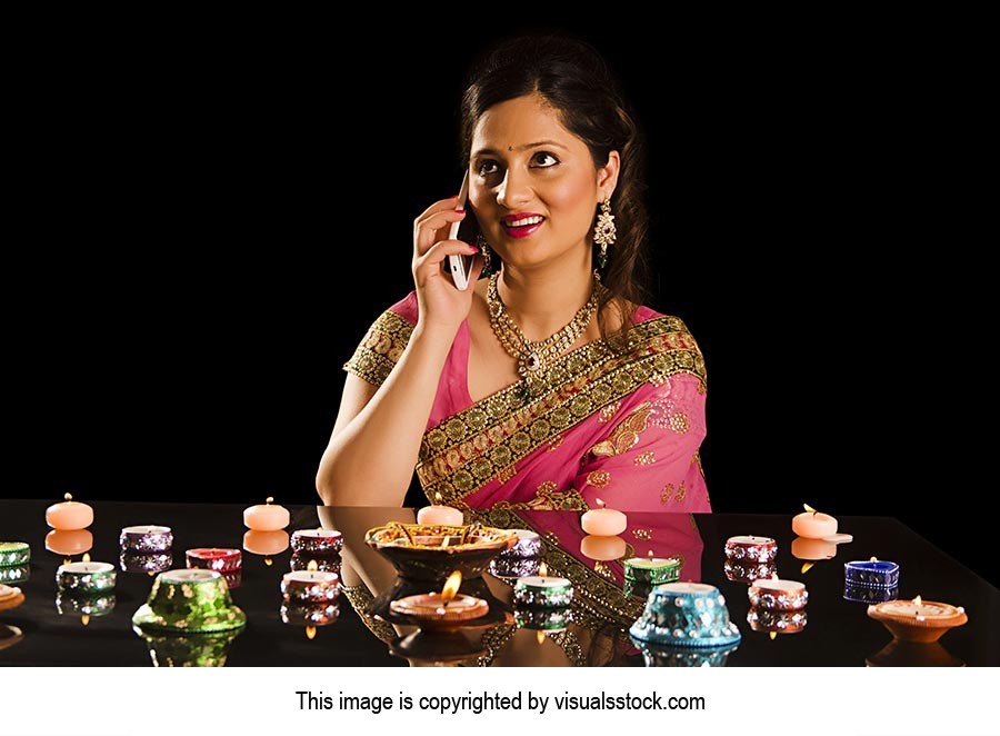 Woman Lighting Diyas Talking Phone