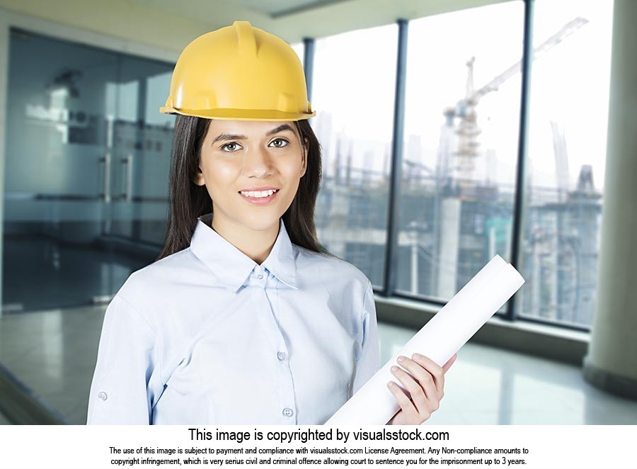 Indian woman civil engineer holding blueprints Building Construction Site