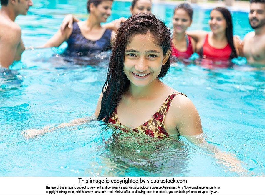 Teenager Girl bathing in-water in-a swimming pool with Friends on