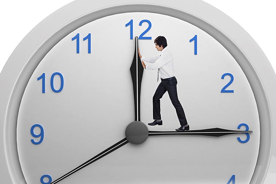 Indian Businessman pushing clock hand inside clock isolated on white