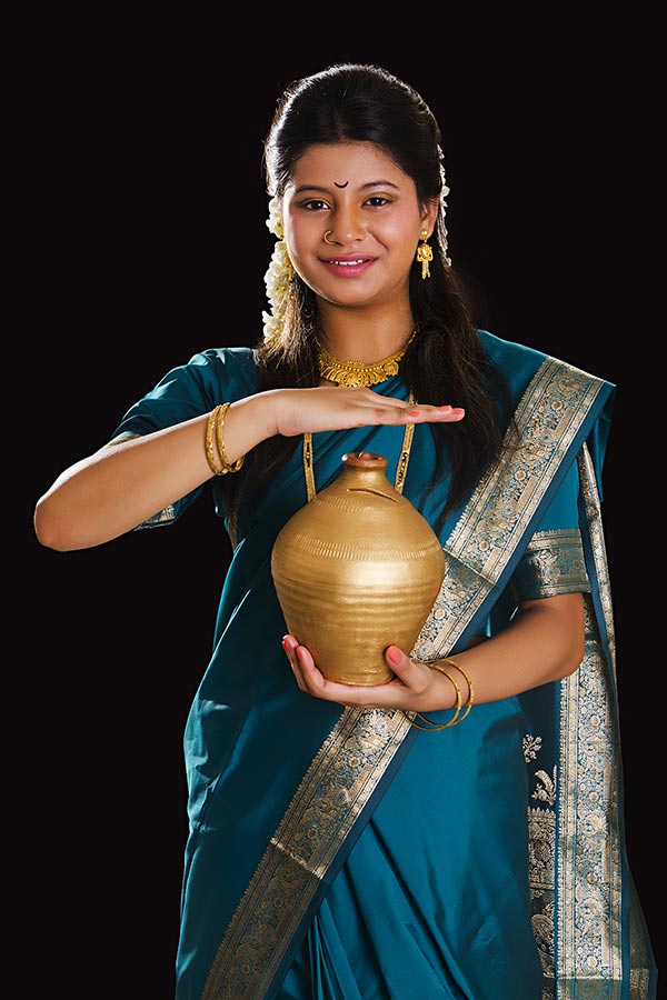 Traditional indian Marathi Woman holding piggy bank hand Protecting