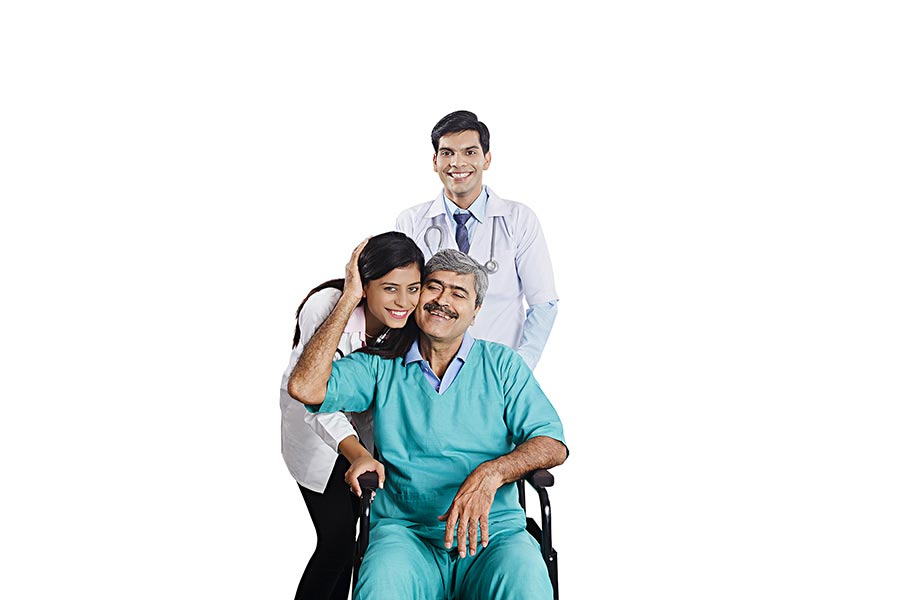 Indian Doctor and nurse caring for elderly patient inwheelchair Health
