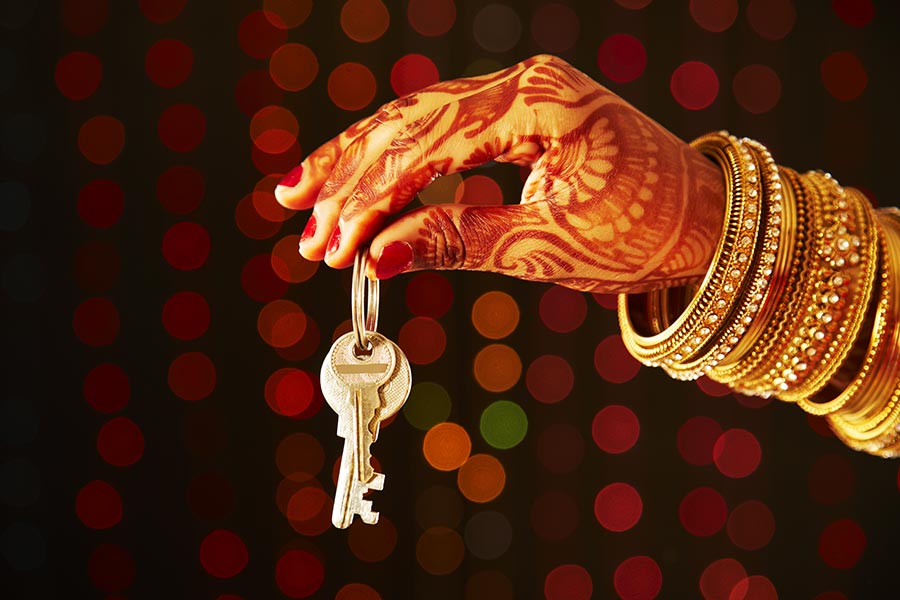 Closeup Indian Married woman Hand Holding a house key,RealEstate Concept