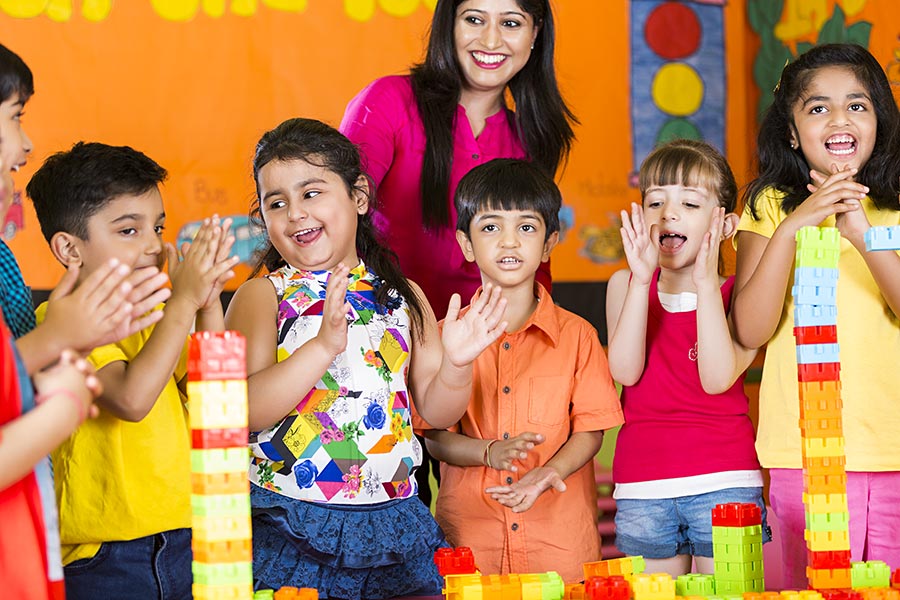 Preschool Teacher With Children Students Playing Toy-Blocks And