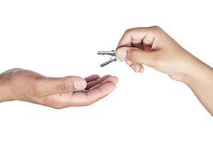 Woman Hand Handing Key To Man Hand- Hand Giving Ho