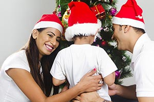 Son And Father Decorate Christmas Tree Mother Smil