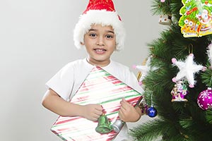 little boy celebrates Christmas Tree presents gift