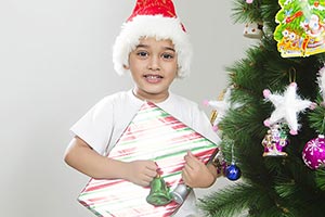 little boy celebrates Christmas Tree presents gift