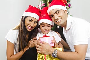 Son Receiving Christmas Gift Parents Smiling