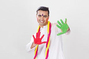 Indian Man showing colourful palm celebrating holi