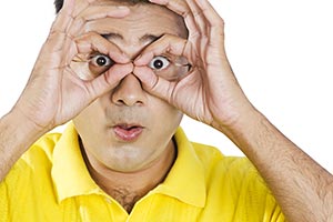 Man Looks Through Finger Binoculars