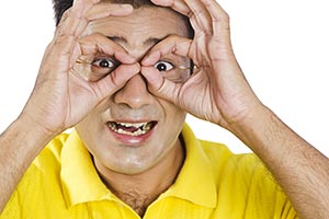 Man Looking Through Finger Binoculars