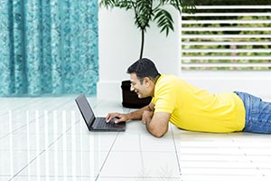 Man Using Laptop Lying Floor