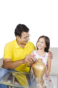 Father Daughter Putting Coin Piggybank