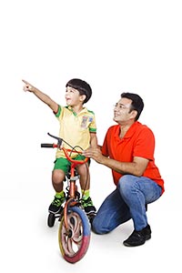 Father Teaching Son Ride Bicycle Pointing