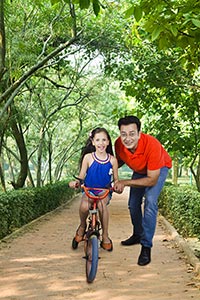 Father Teaching Daughter Ride Bicycle Sidewalk