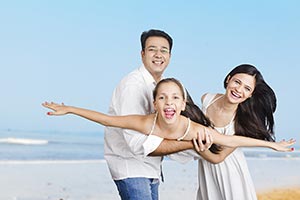 Happy Parents Daughter Lifting Enjoying Beach