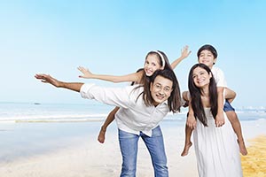 Parents Giving Piggyback Ride Children Beach