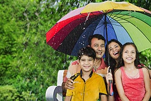 Family Enjoy Rain Under Umbrella