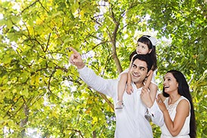 Mother Father Carrying Daughter Shoulders Pointing