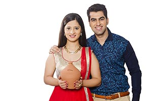 Happy Indian Couple Saving Money Piggybank