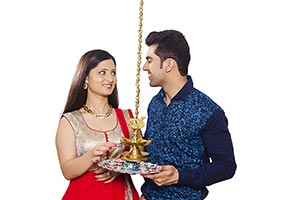 Happy Couple Lighting up Oil Lamps During Diwali