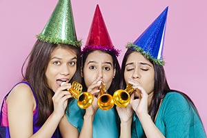 Teenage Girls Blowing Party Horn